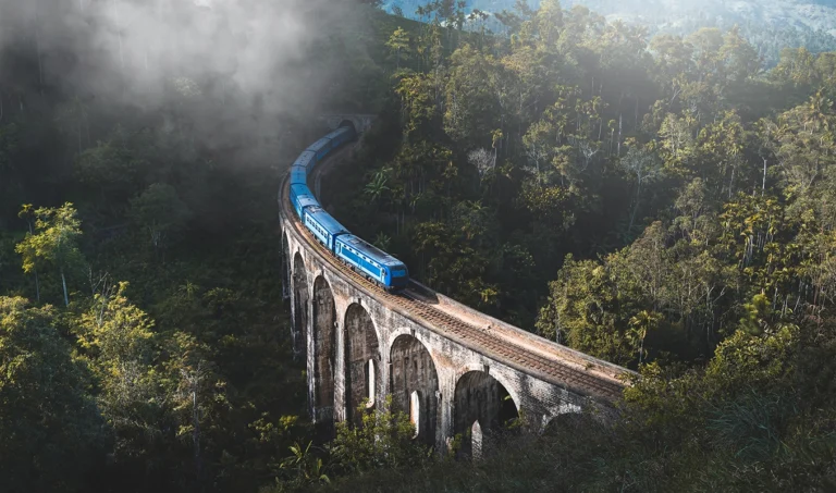 Blue train crossing the Nine Arches Bridge in Ella - Book with local travel agents in Sri Lanka